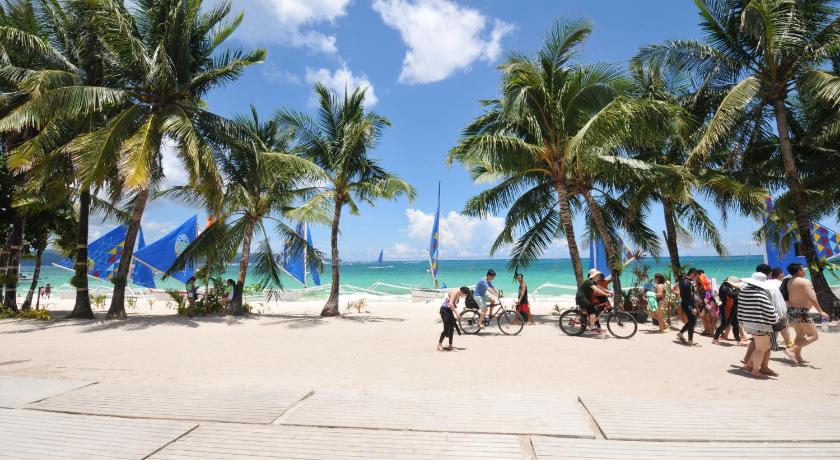 people on a beach with palm trees, Astoria Current in Boracay Island