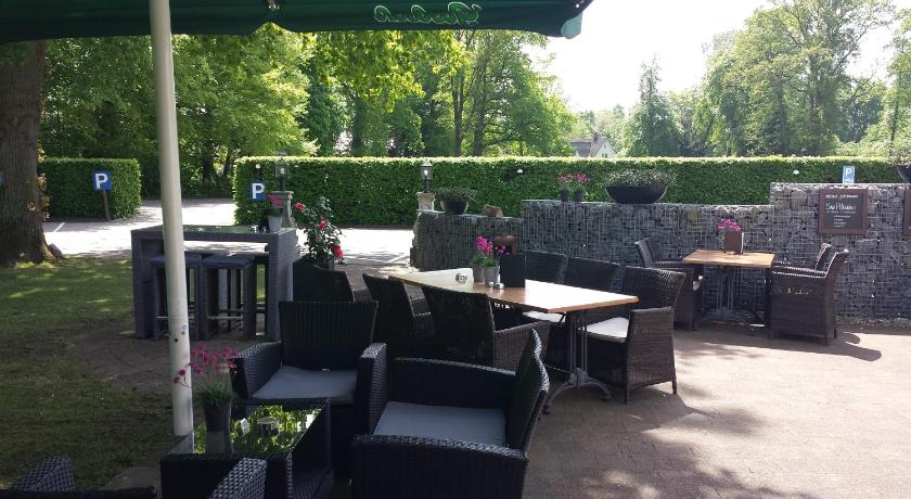 a patio area with chairs, tables and umbrellas, Hotel Restaurant Het Witte Paard in Delden