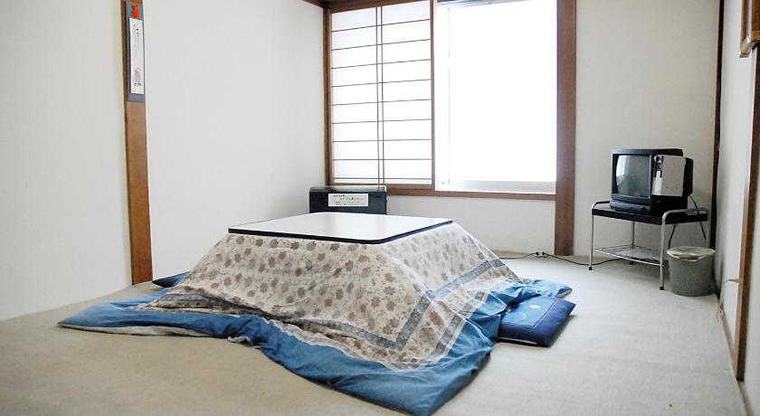 a bed in a room with a window, Family House Akashiya in Yuzawa