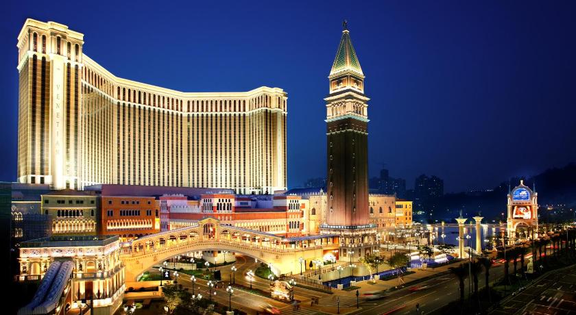 a large clock tower towering over a city at night, The Venetian Macao in Macau