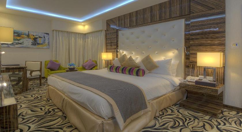 a room with a bed, a rug, and a painting on the wall, Orchid Vue Hotel in Dubai