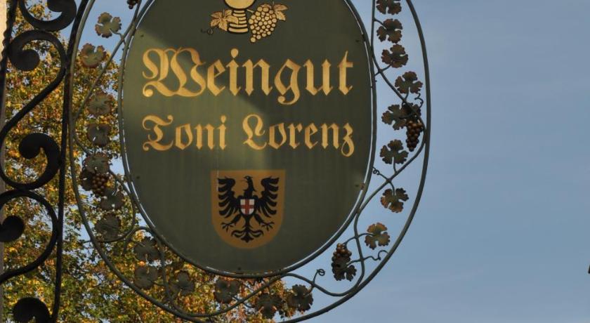 a sign on a pole in front of a tree, Weinhotel Landsknecht in Sankt Goar