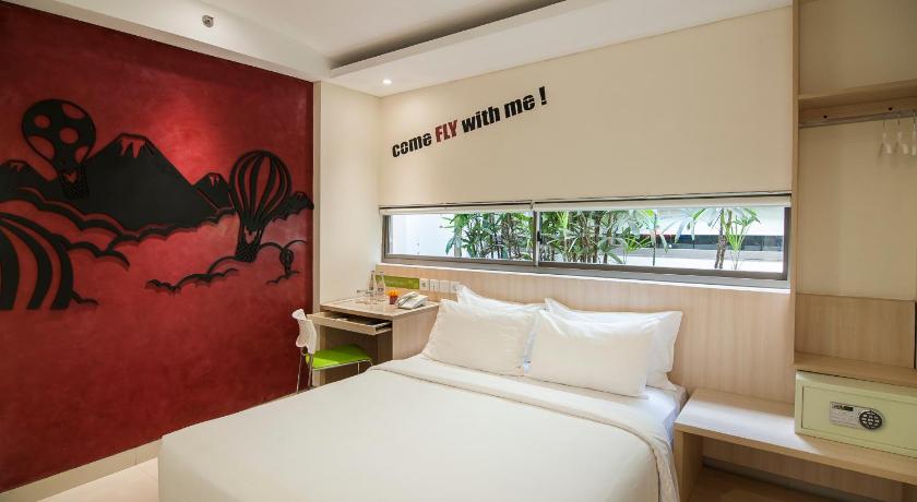 a bedroom with a bed and a painting on the wall, Grandmas Plus Hotel Legian in Bali