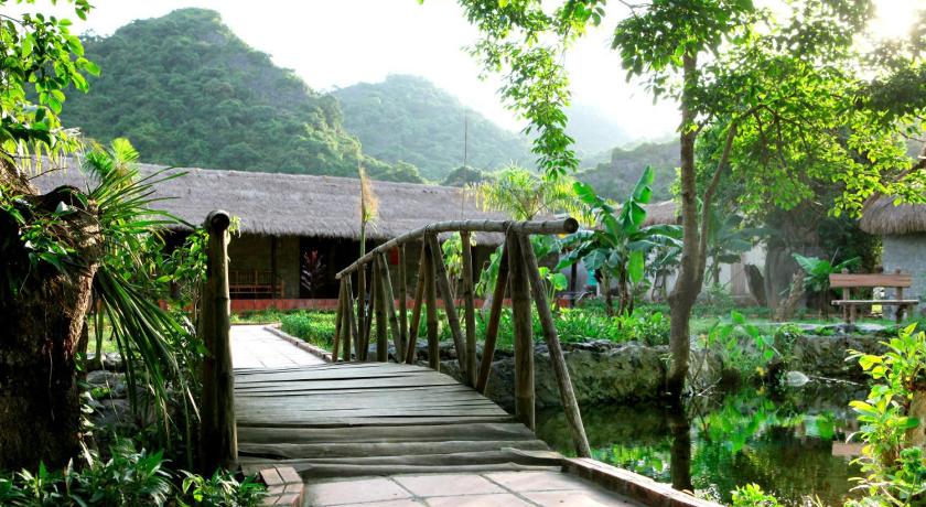 a wooden walkway leading to a garden area, Whisper Nature Bungalow in Cat Ba Island