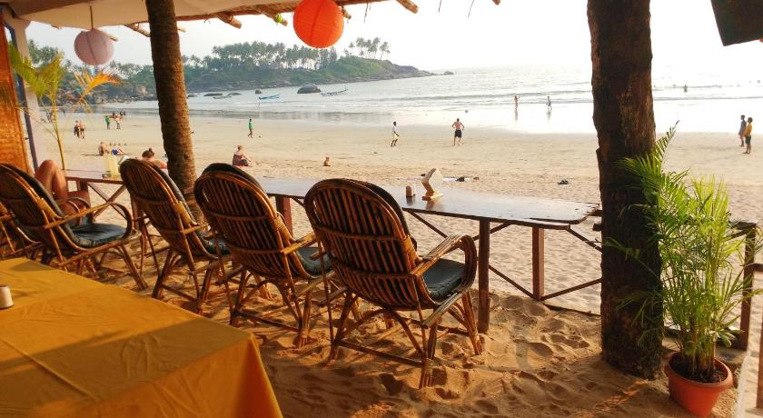 a beach area with chairs, tables and umbrellas, Royal Touch Beach Huts Resort in Goa