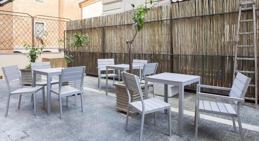 a patio area with chairs, tables, chairs and umbrellas, La Casa delle Acciughe Guest House in La Spezia