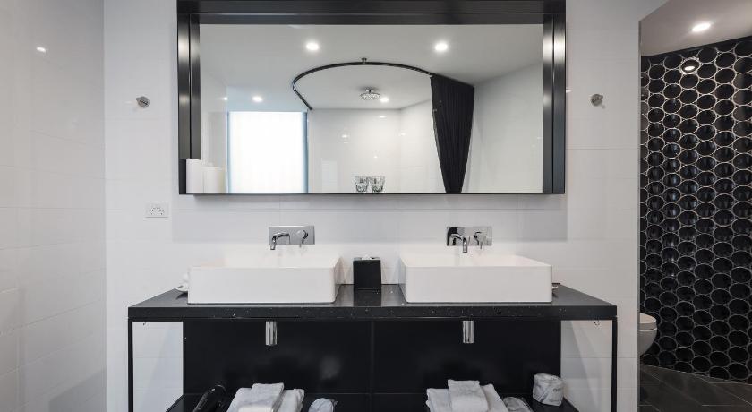 a bathroom with a sink and a mirror, The Woolstore 1888 by Ovolo in Sydney