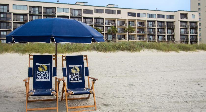 a blue umbrella sitting on top of a sandy beach, Peppertree by the Sea by Capital Vacations in Myrtle Beach (SC)
