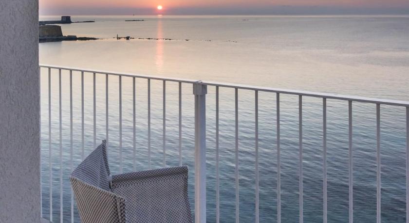 a chair sitting on top of a beach next to the ocean, Gaura Apartments in Trapani