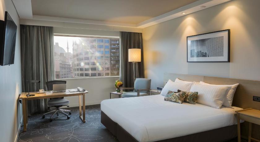 a hotel room with a bed and a desk, PARKROYAL Darling Harbour, Sydney in Sydney