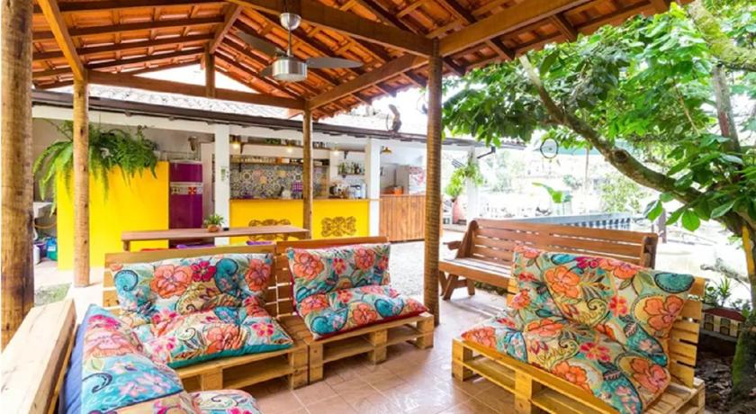 a living room filled with furniture and umbrellas, Maracuja Hostel in Paraty