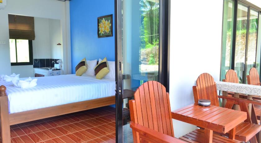 a room with a bed, chair, and table in it, Lanta Phongpipat Resort in Koh Lanta