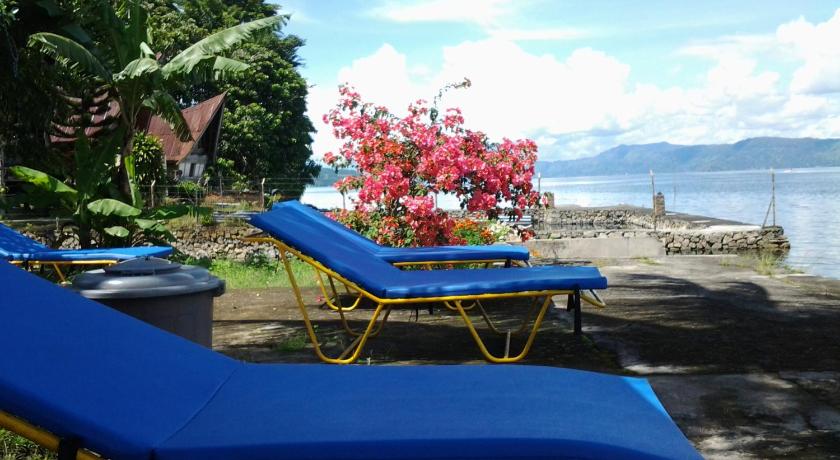 a row of beach chairs sitting on top of a beach, Sony Guesthouse in Samosir
