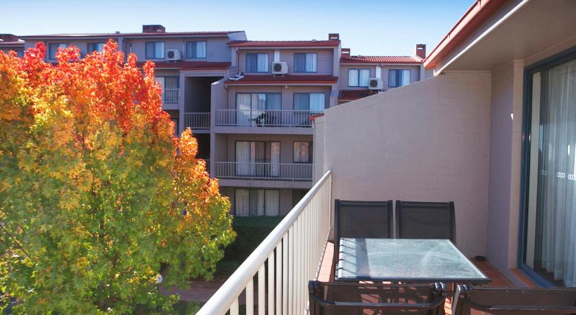 a patio area with a balcony and a table with chairs, Pinnacle Apartments in Canberra