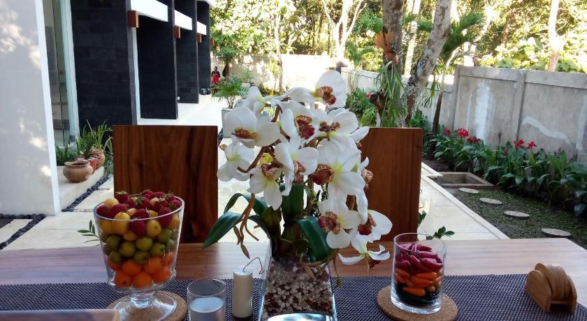 a table topped with a vase filled with flowers, Narvik Villa in Lombok