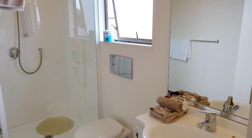 a bathroom with a toilet, sink, and shower stall, Hobson's Choice Motel in Dargaville