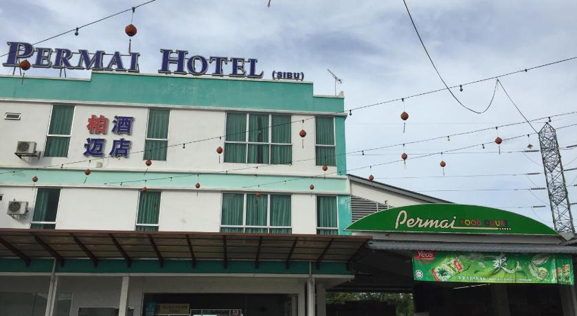 a large building with a lot of signs on it, Permai Hotel in Sibu