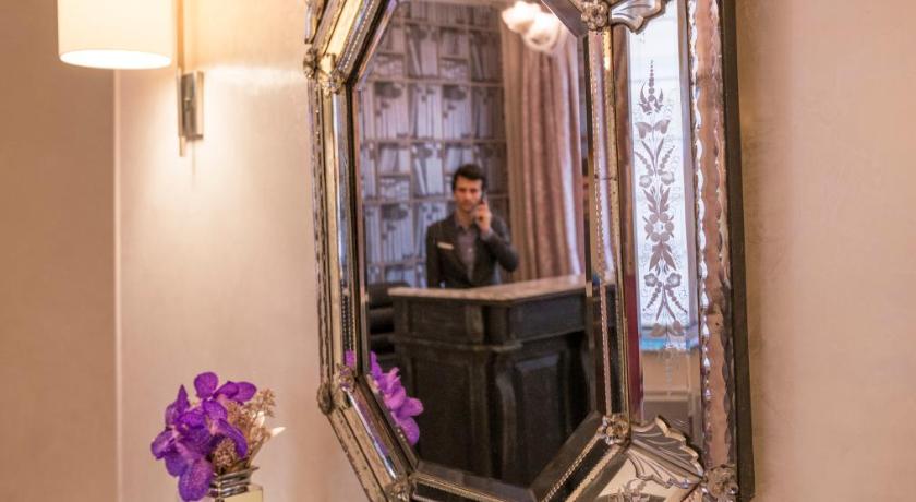 a reflection of a woman taking a picture of herself in a mirror, Hotel Magda Champs Elysees in Paris
