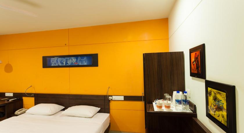a hotel room with a bed and a television, Ginger Hotel Jaipur in Jaipur
