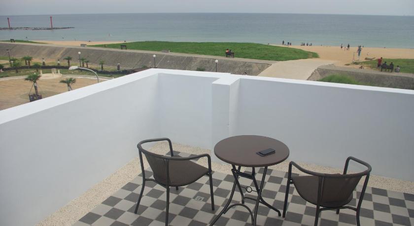 two chairs and a table in the middle of a beach, See Your Dreams B&B in Penghu