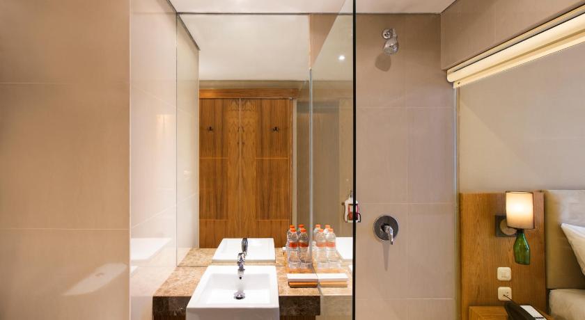 a bathroom with a double sink and a mirror, Yellow Star Ambarukmo Hotel in Yogyakarta