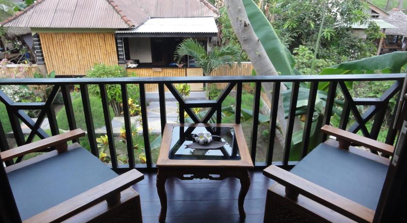 a cat sitting on top of a wooden table, Villas Ganjor in Lombok