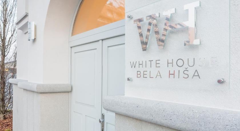 a white wall with a sign on the side of it, White House Bela Hisa in Ljubljana