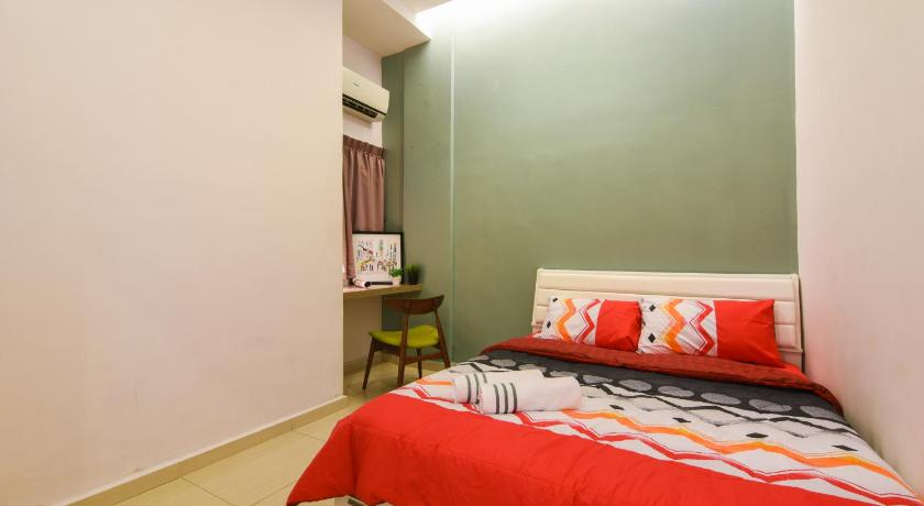 a bedroom with a red and white striped bedspread, Saffron Stay Melaka in Malacca
