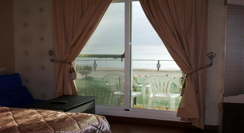 a bedroom with a window overlooking a lake, Ibiza Kenting Hotel in Kenting