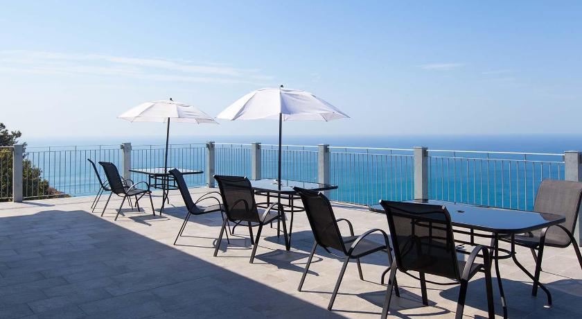 a patio area with chairs, tables and umbrellas, Hotel Due Gemelli in Riomaggiore