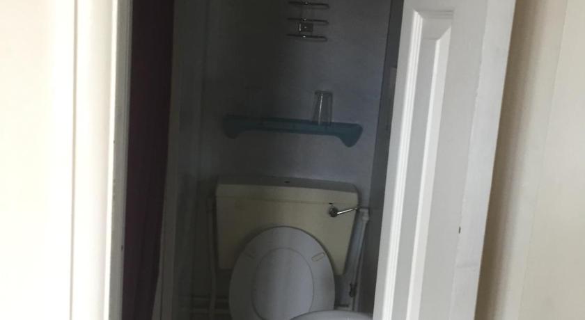 a white toilet sitting in a bathroom next to a wall, Colnbrook Lodge Guest House in London