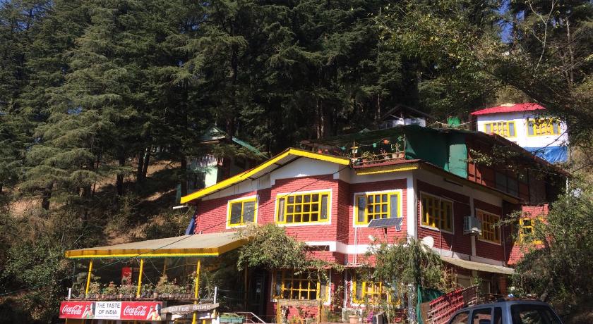 a red brick building with a bunch of trees around it, Mcleodganj Bed And Breakfast in McLeod Ganj