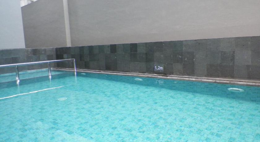 a swimming pool with a blue tub and blue walls, Amaris Hotel Malioboro in Yogyakarta