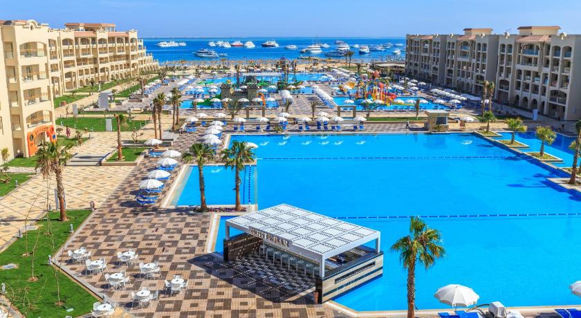 a beach with a pool, chairs and tables, Pickalbatros White Beach Resort - Hurghada in Hurghada