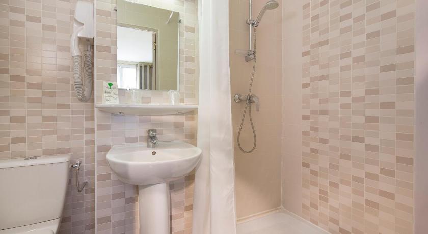 a bathroom with a shower, sink, and mirror, Hotel De La Cite Rougemont in Paris