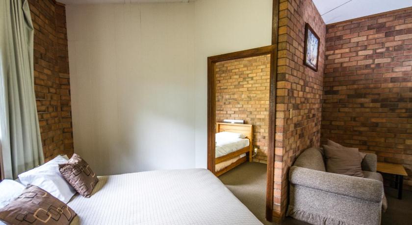 a bedroom with a bed, chair and a window, Mannum Motel in Murray Bridge