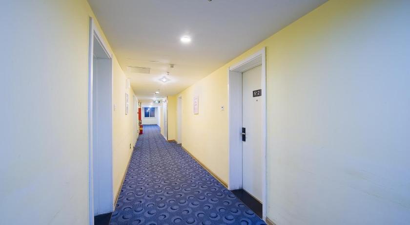 a hallway with a door leading to a room with a blue floor, 7 Days Inn Beijing Liangxiang Changyang Roundabout Branch in Beijing