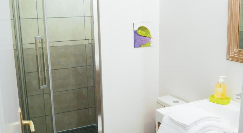 a white toilet sitting next to a shower in a bathroom, Studio Premium Zenith Arenes Purpan in Toulouse