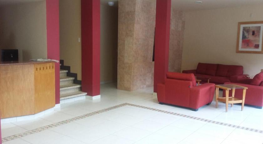 a living room filled with furniture and a red carpet, Hotel Virginia in Oaxaca