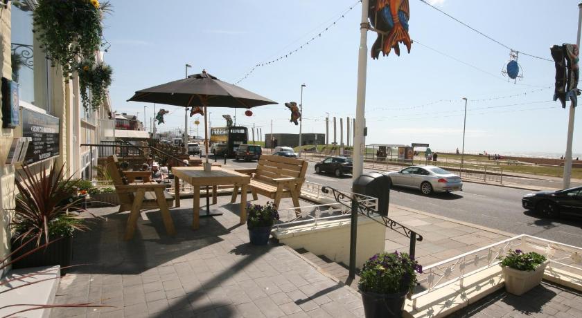 a patio area with tables, chairs and umbrellas, The Blenheim Mount Hotel in Blackpool
