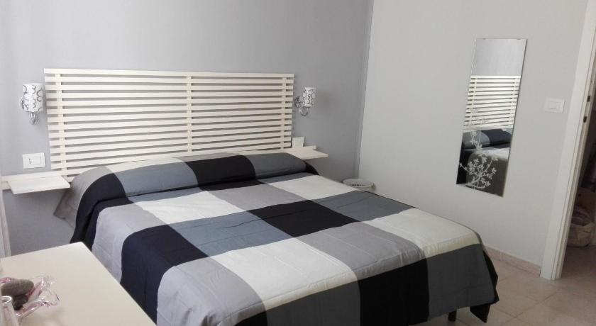 a bed with a white comforter and pillows, Su per i Coppi in Riomaggiore