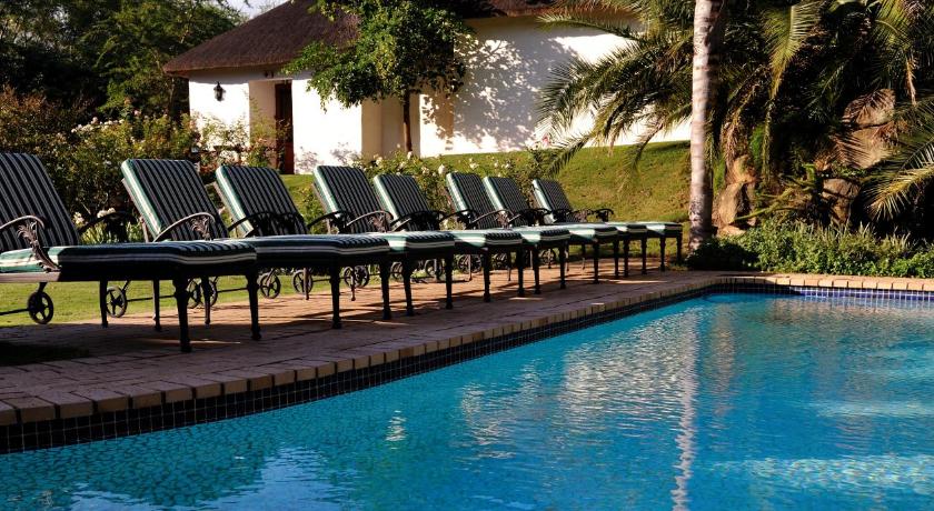 a row of benches in front of a pool of water, Woodall Country House and Spa in Addo
