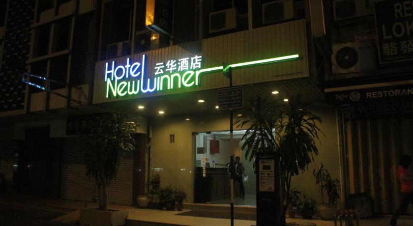 a neon sign hanging from the side of a building, Hotel New Winner in Kuala Lumpur