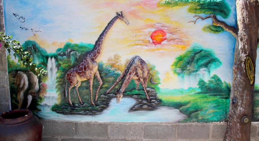 a painting of a giraffe and a statue of a giraffe, Hoang Nga Guest House in Phan Thiet