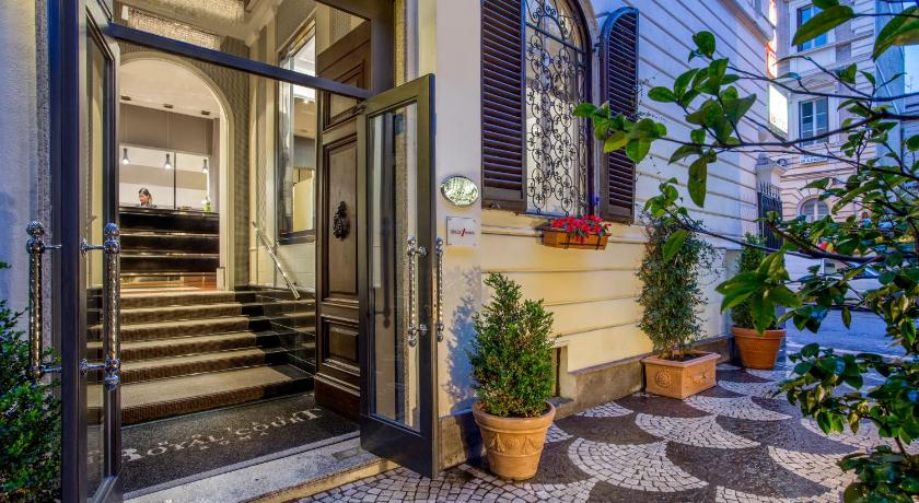 a building with a door open and a staircase leading up to it, Royal Court Hotel in Rome