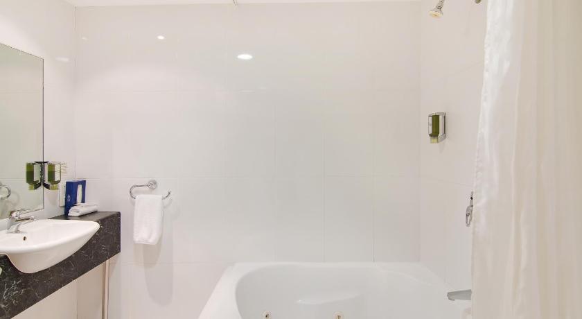 a white bath tub sitting next to a white sink, Boulevard on Beaumont in Newcastle