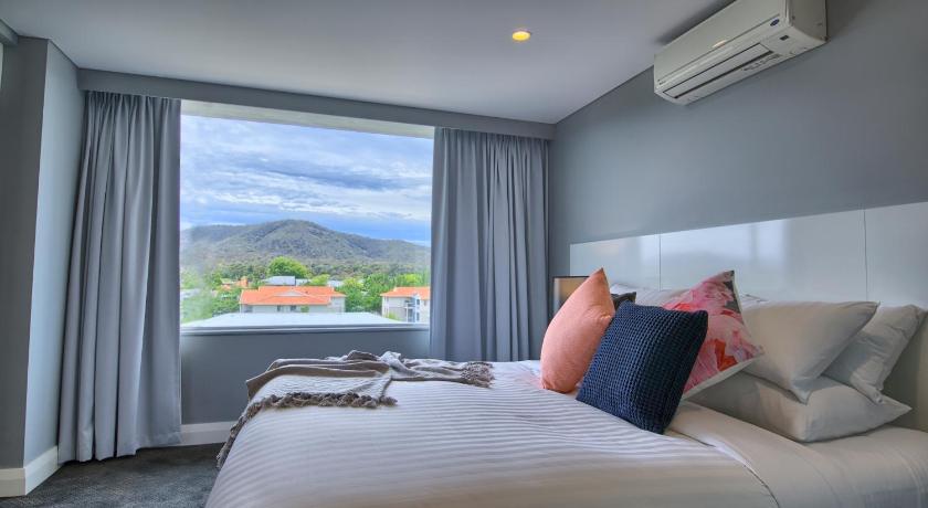 a hotel room with a bed and a window, Canberra Rex Hotel and Serviced Apartments in Canberra