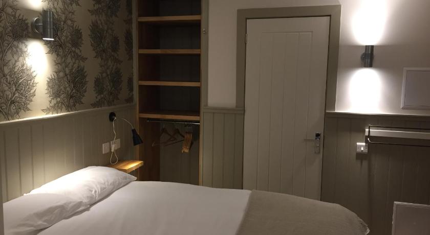 a bedroom with a bed and a lamp, The Harbour Guest House in Irvine