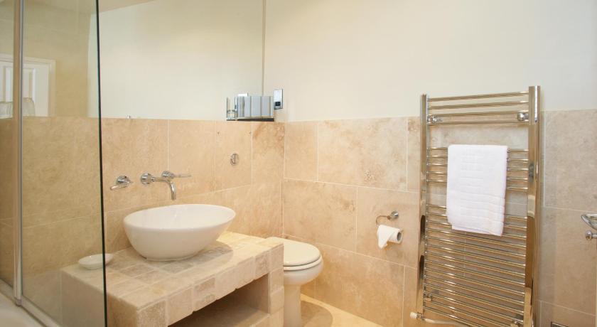 a bathroom with a toilet, sink, and shower stall, Urban Beach Hotel in Bournemouth