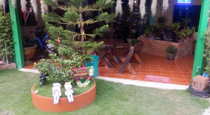 a garden area with plants and a bench, Kevin Resort in Rayong
